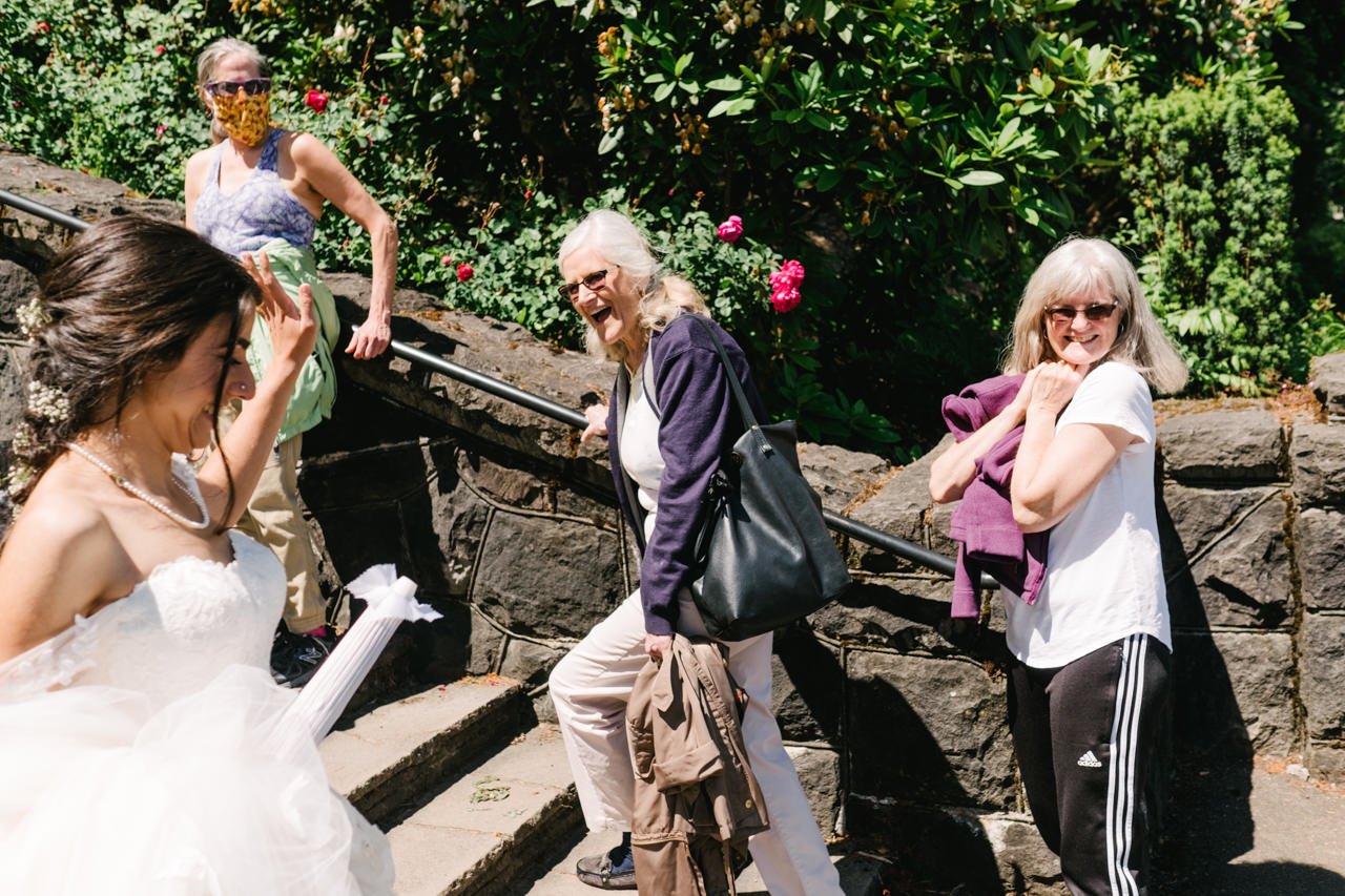  Bride walks by cheering ladies at rose garden 