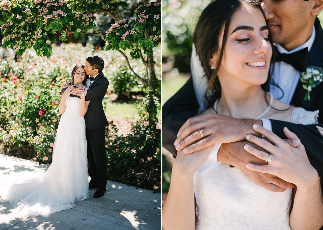  Bride and groom embrace in shade of rose bushes 