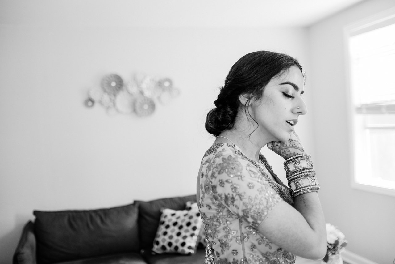  Bride in bangles and Sari adjusts earrings 