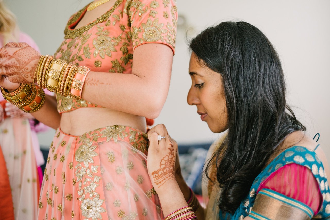  Bridesmaid adjusts sari waist 
