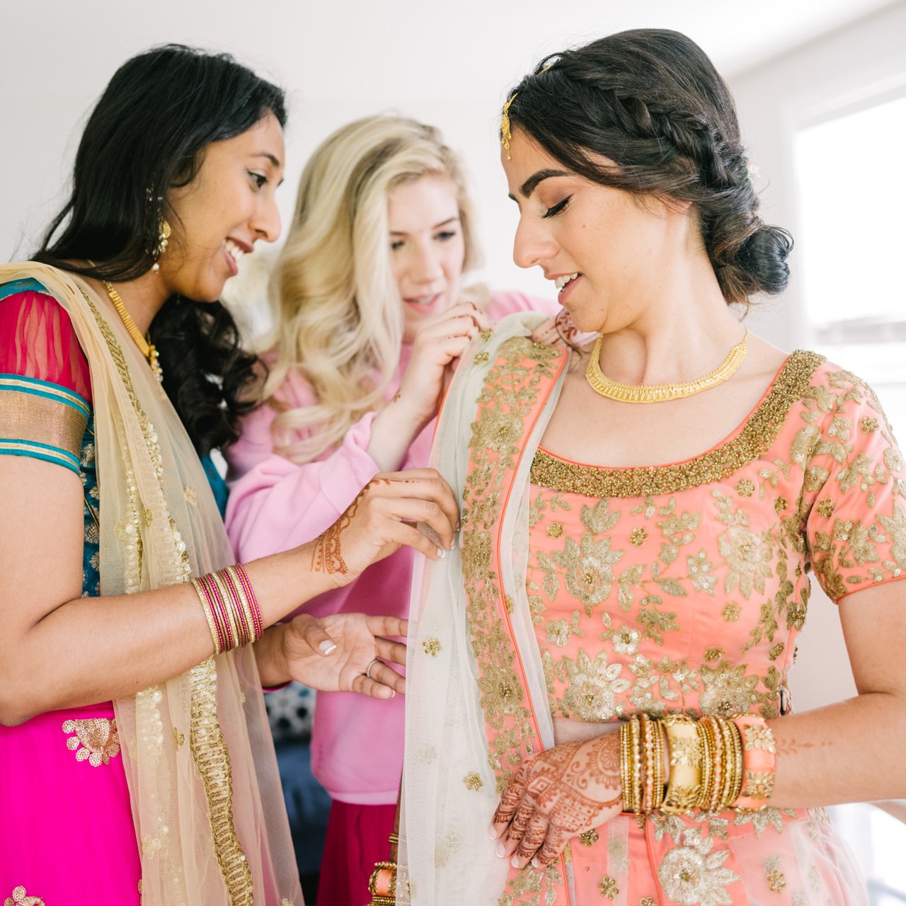 Bride receives help with sash around sari 