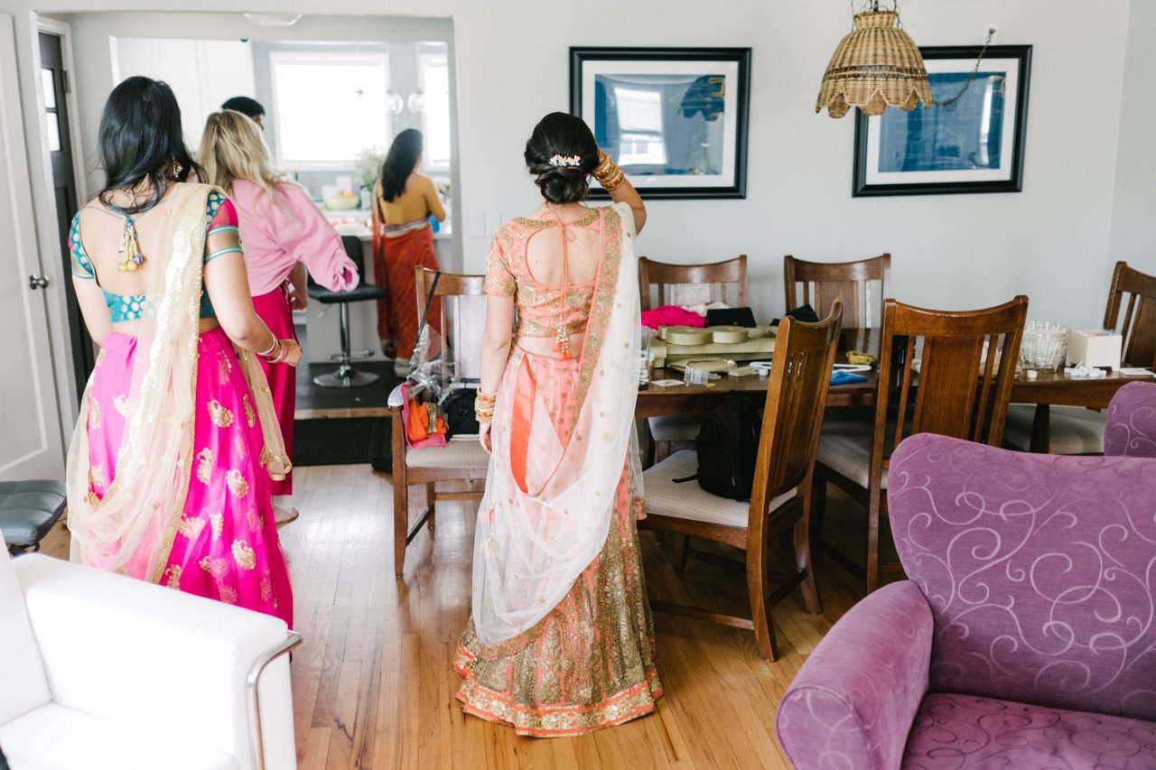  Bride in wedding sari faces away in living room with purple chair 