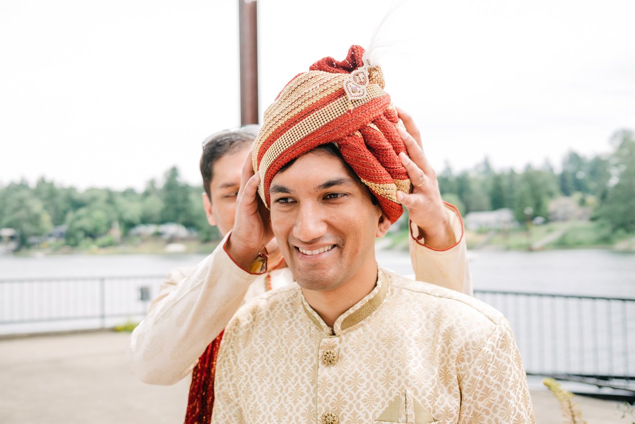  Groom has red and gold turban adjusted before ceremony 