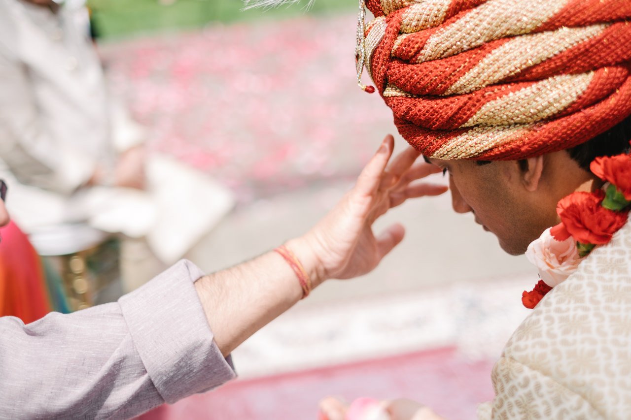  Hand touches Indian's groom forehead 