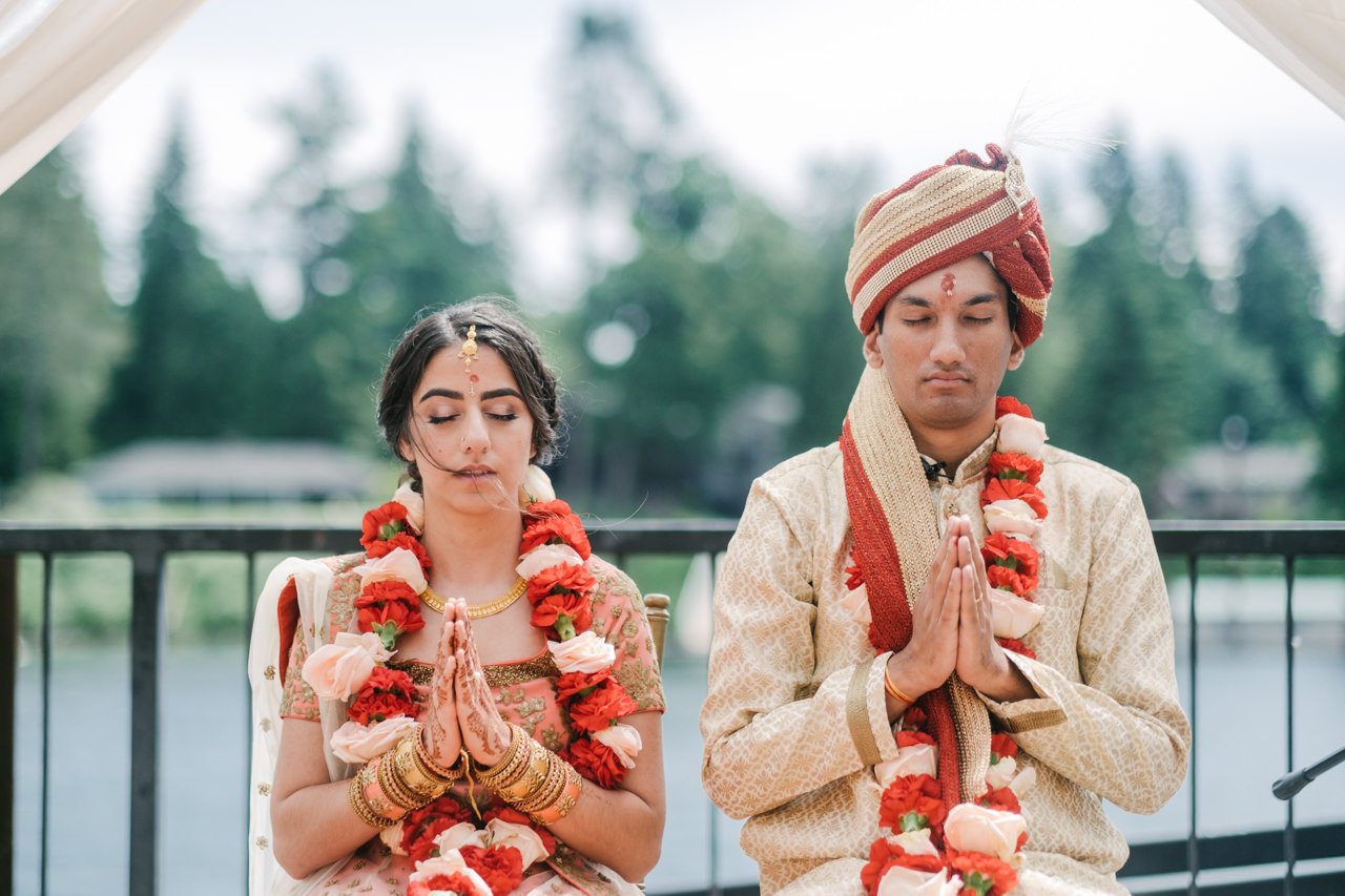 Indian wedding couple folds hands in prayer during ceremony 
