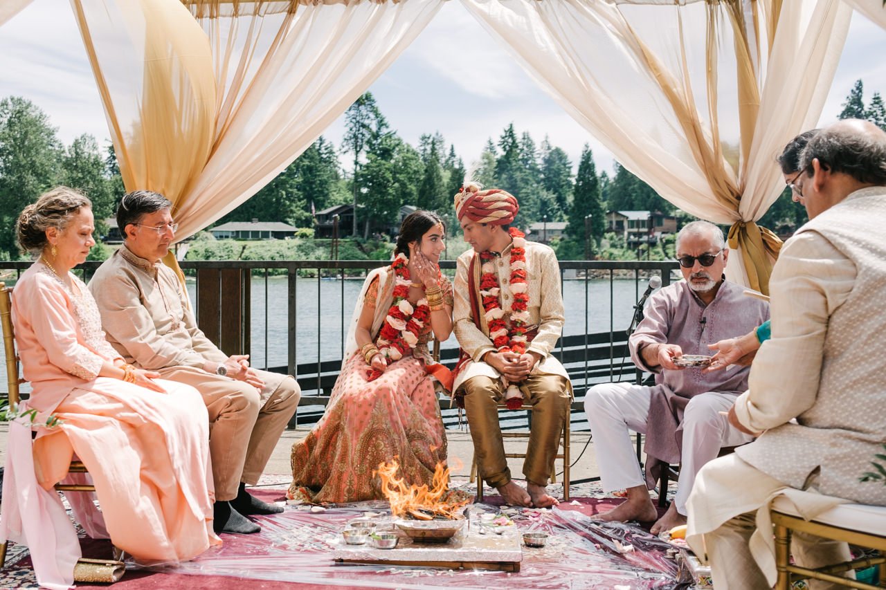  Indian bride and groom share quiet words in front of fire during Indian wedding ceremony 