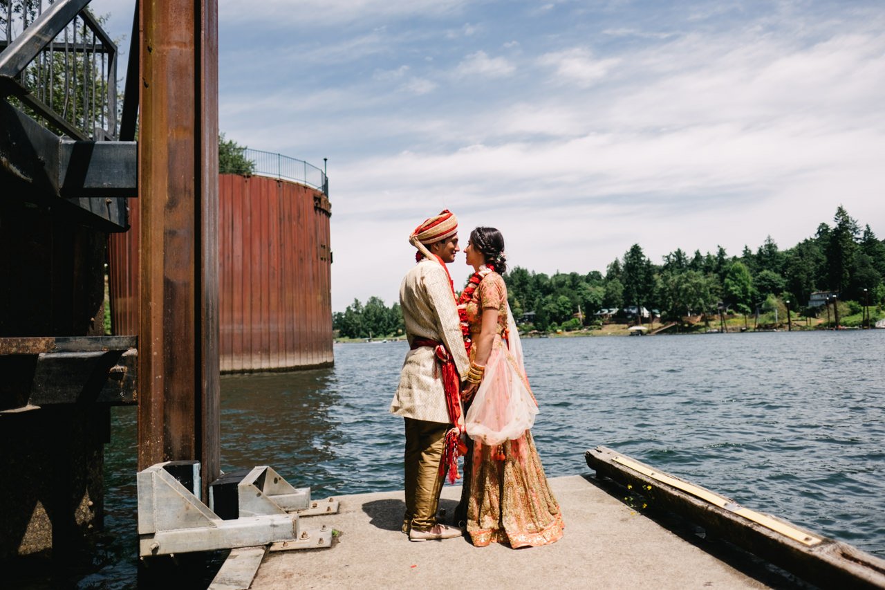  Indian couple just married by river with gold and red traditional attire 