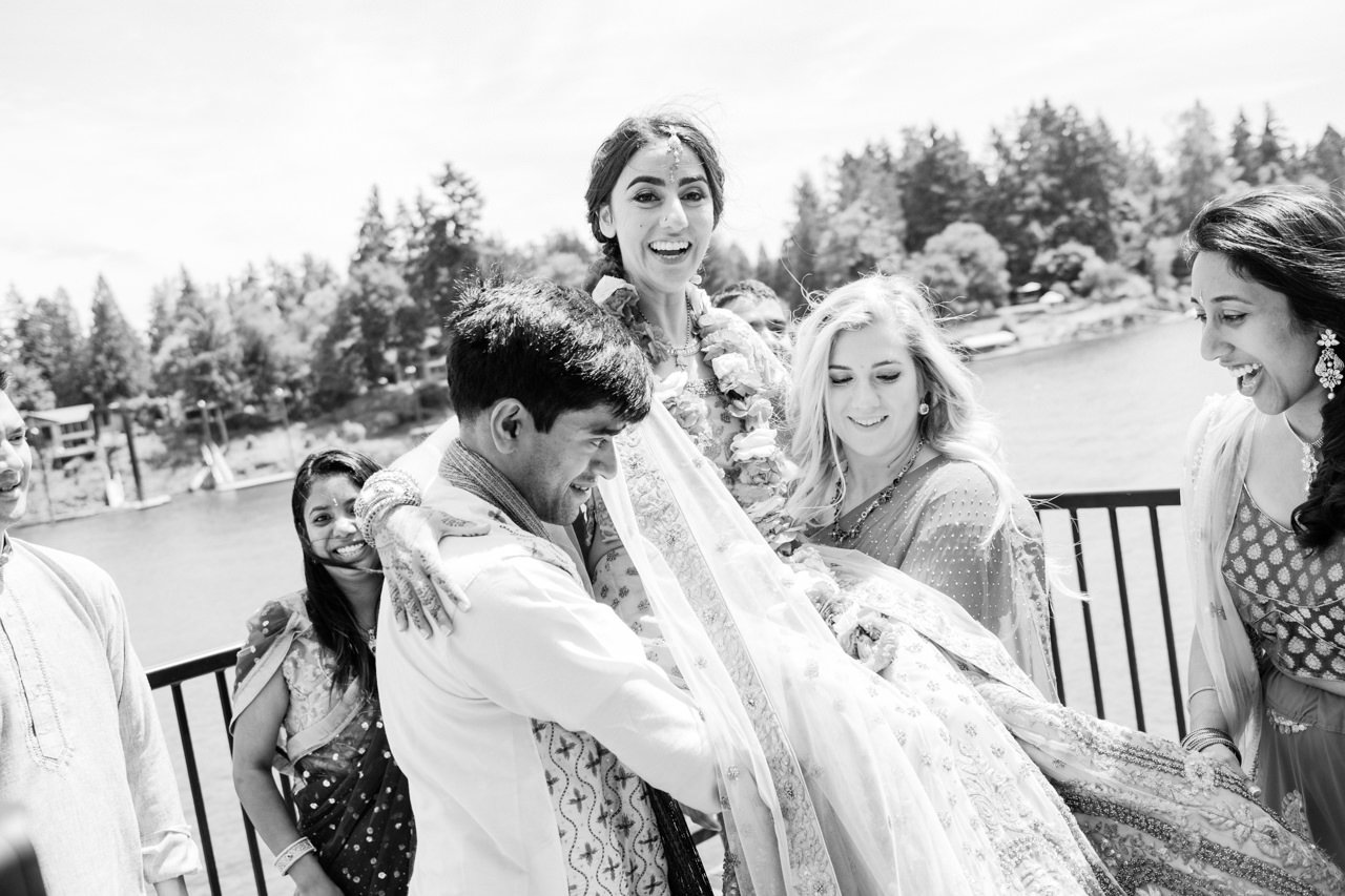  Bridal party lifts up bride into the air with Indian wedding attire 