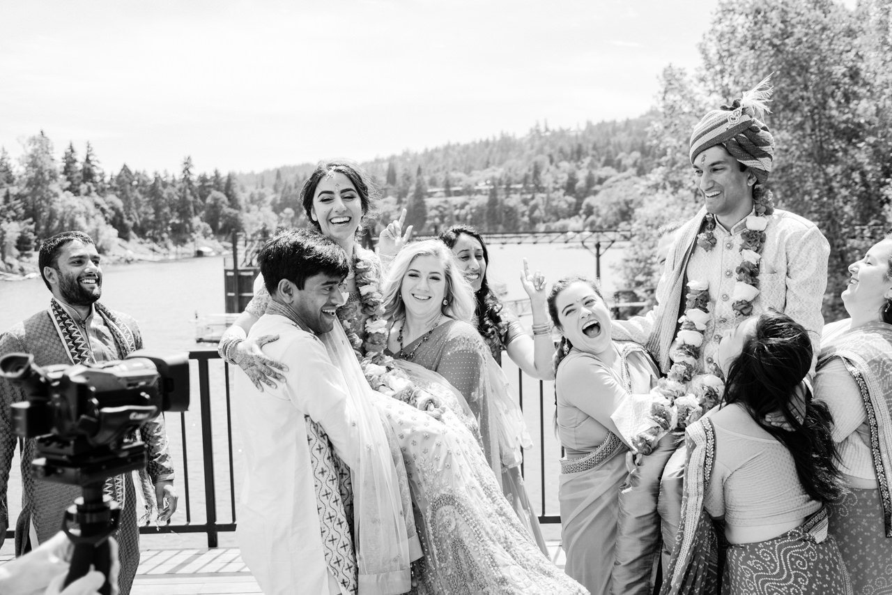  Indian wedding couple lifted in air by wedding party in black and white candid photo 