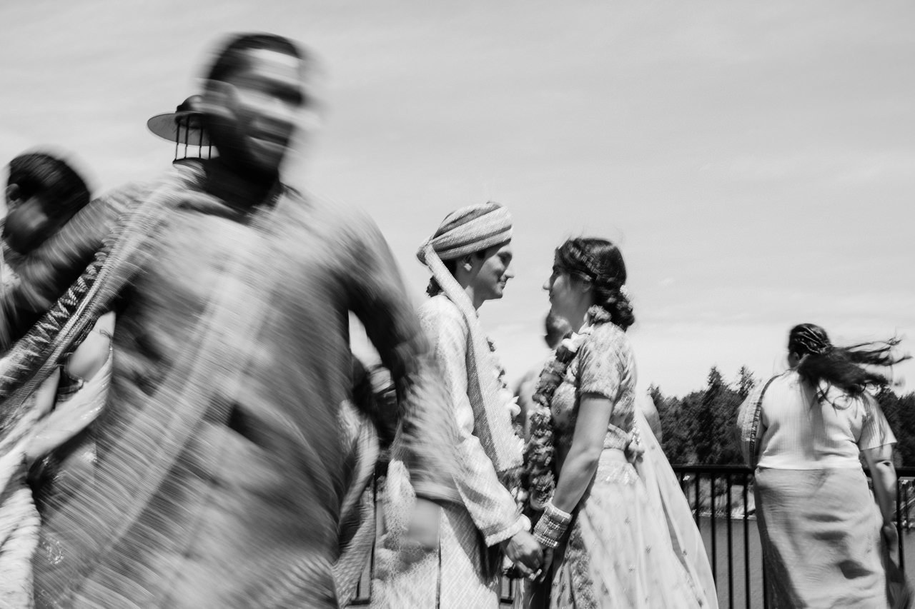  Creative blur photo of wedding party dancing around motionless couple in Indian ceremony 