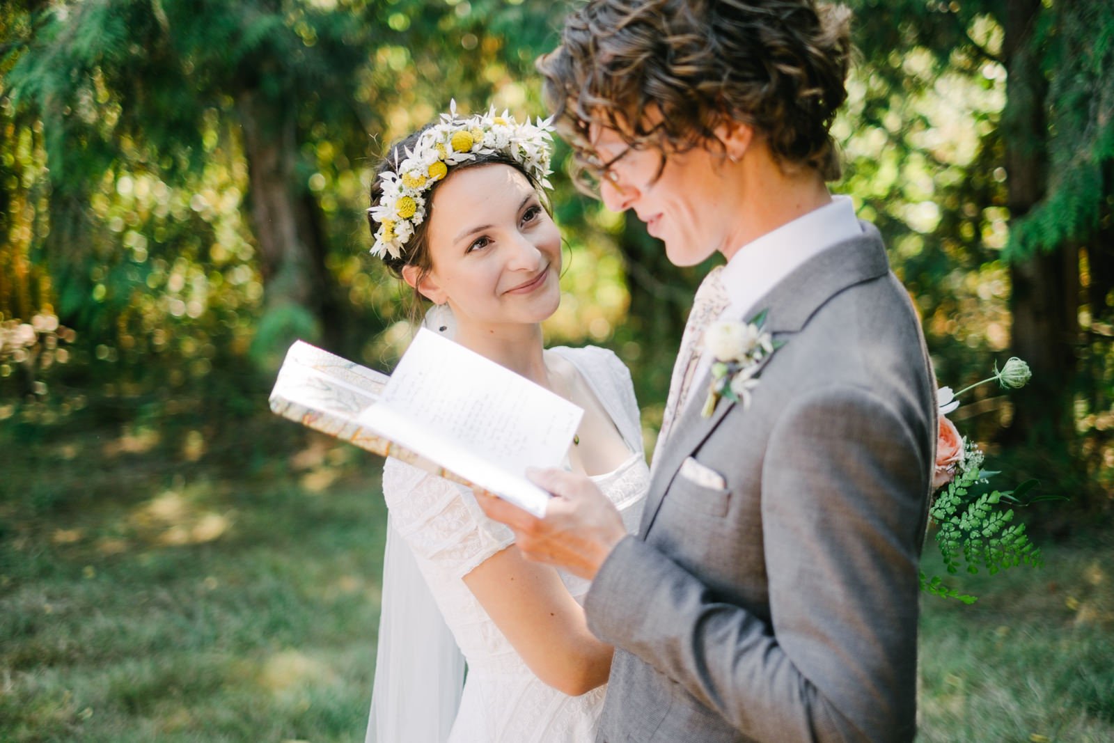  Bride smiles at groom who is reading her gift letter and wrapped package 