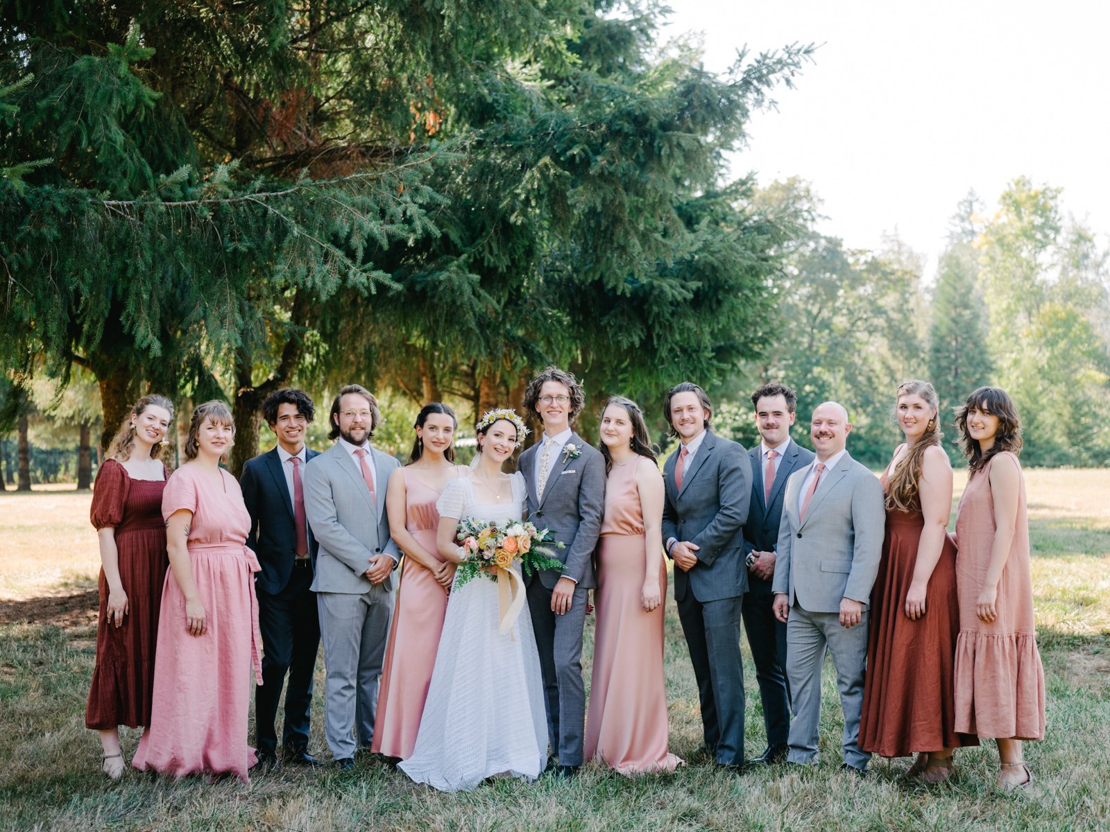  Portrait of entire bridal party under large fir trees with mixed suits and ties 