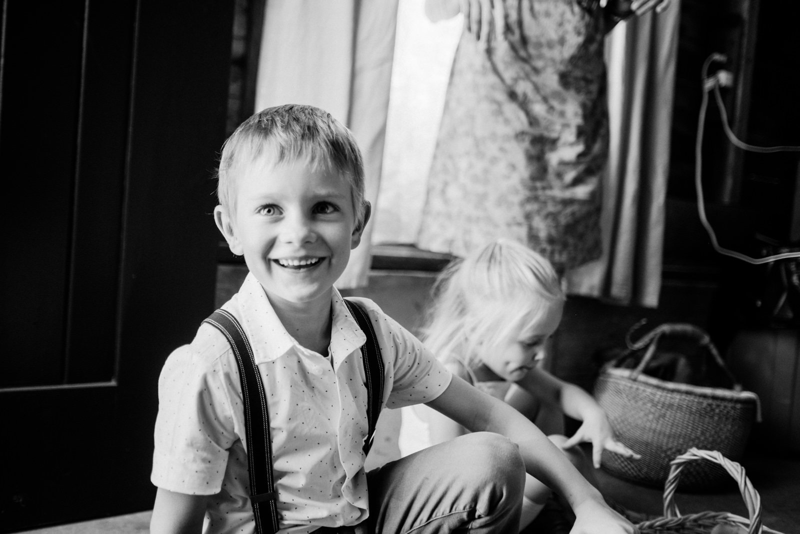  Boy in suspenders laughs before wedding in candid moment 