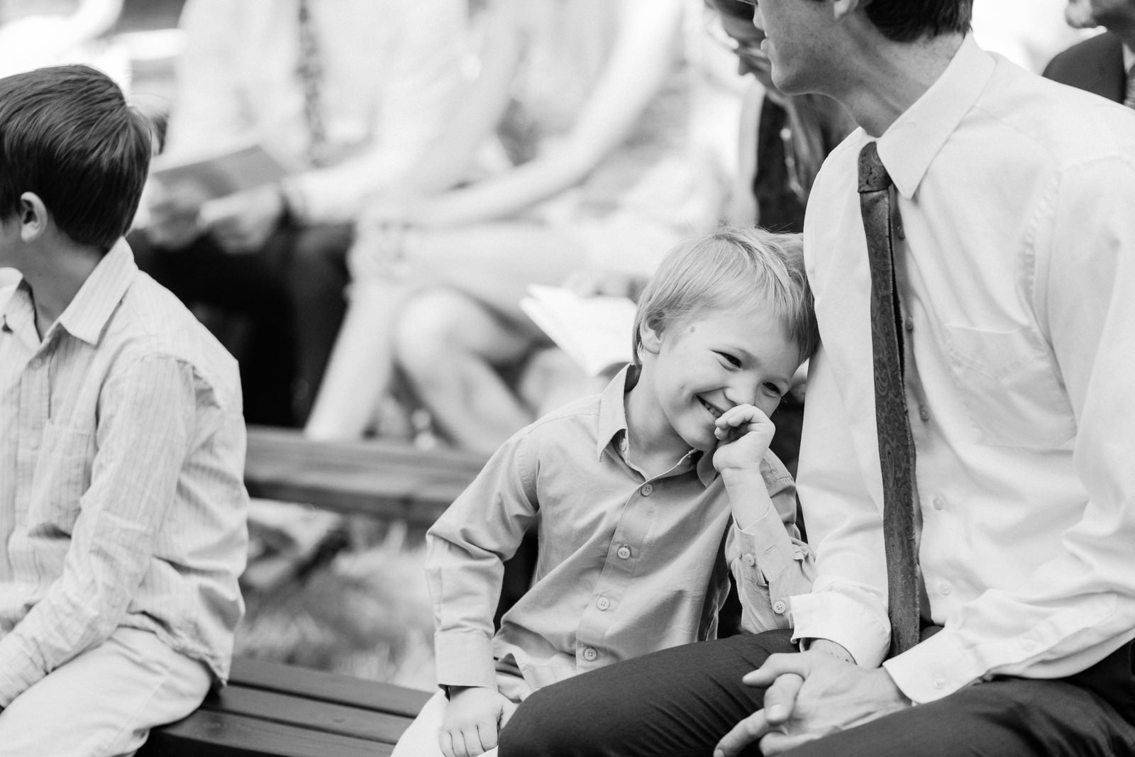  Boy waits and laughs with father on wedding ceremony benches 