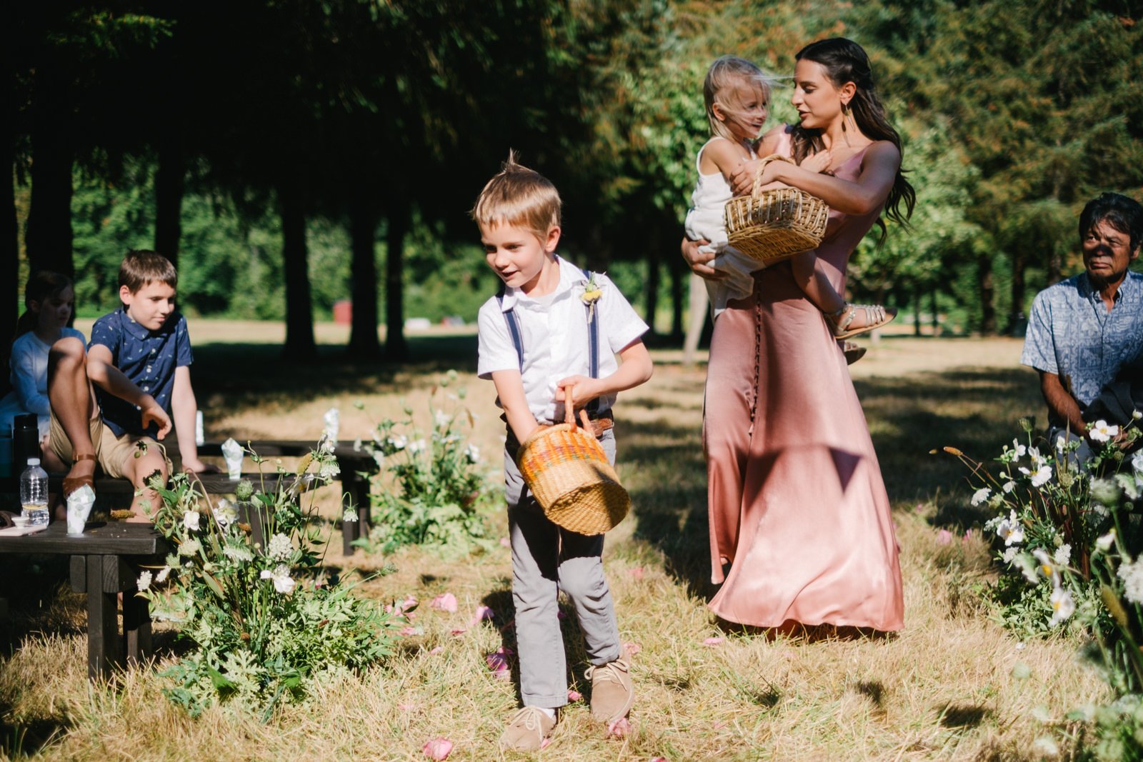  Flower children reach in baskets for flowers while walking down aisle 