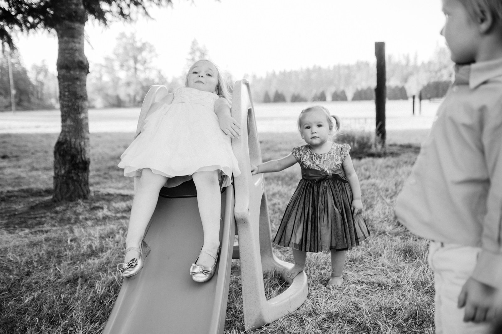  Kids sliding down kiddie slide while others watch in black and white 