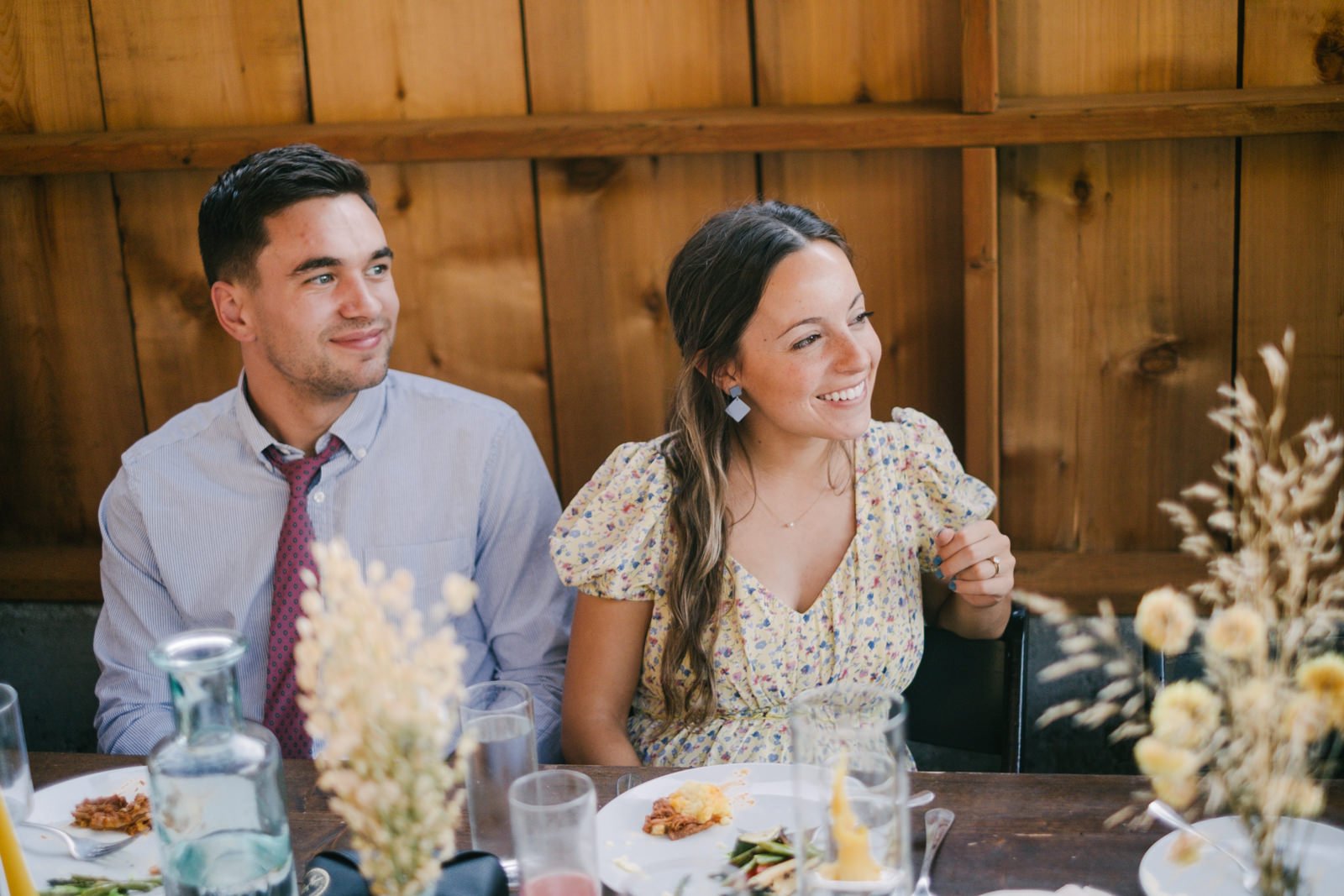  Wedding guests laugh at dinner table 