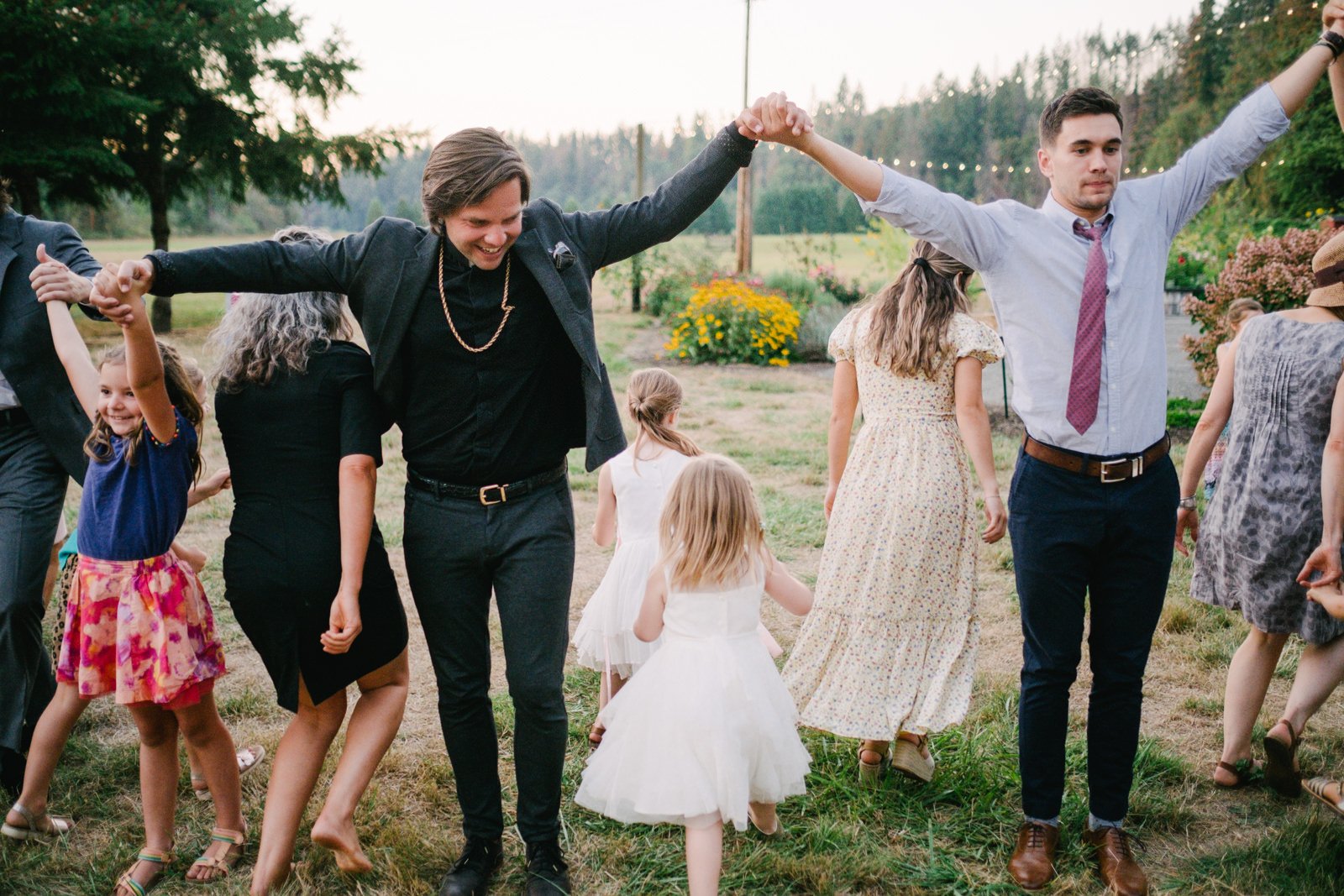  Officiant and guests lock arms in English line dancing 
