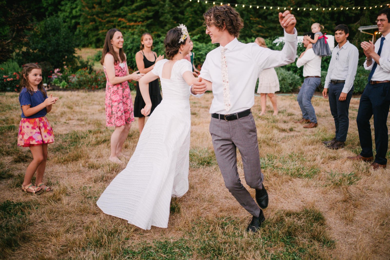  Bride and groom twirl together during English line dancing with guests 