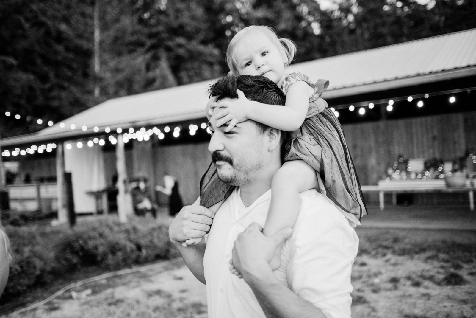  Girl clings to fathers head while on shoulders 