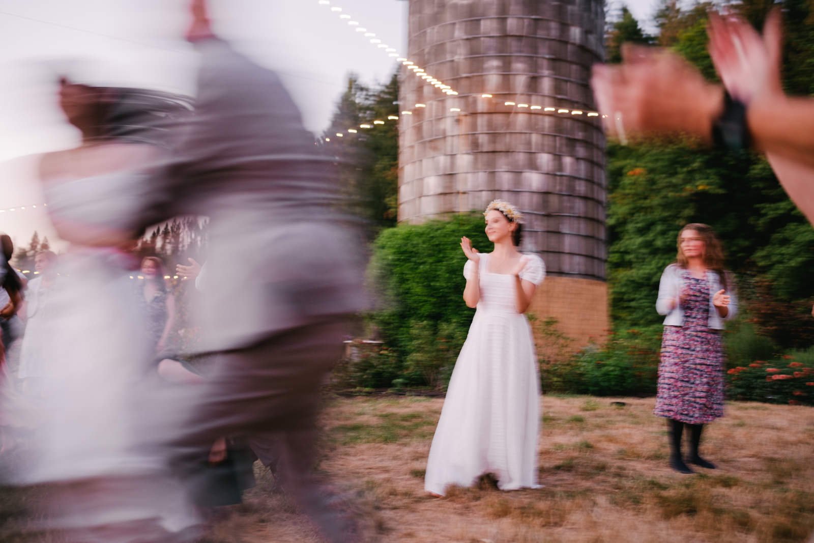  Blurry photo of bride clapping while guests dance through line 