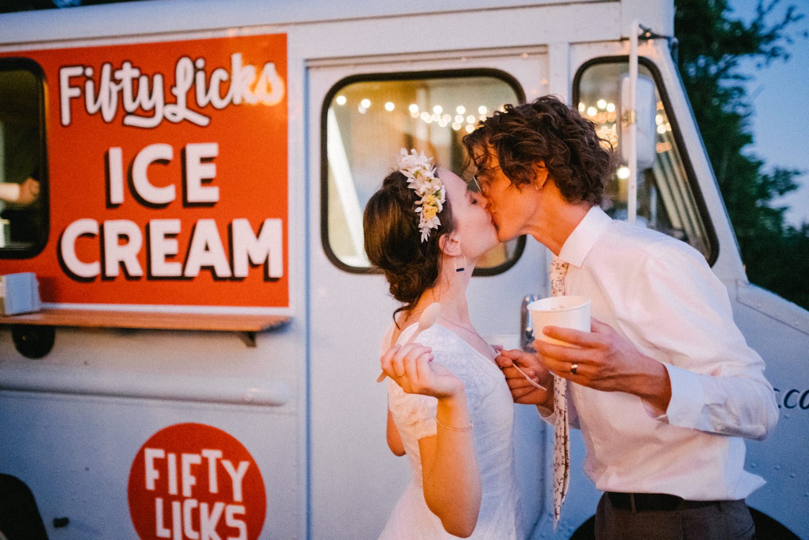  Wedding couple kisses while eating fifty licks ice cream in blue hour 