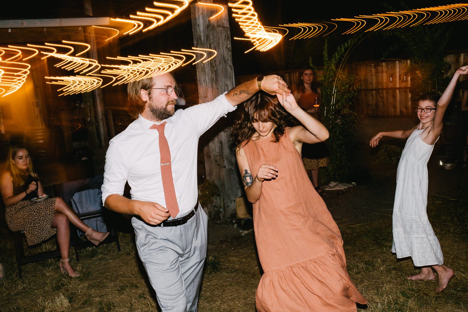  Couple twirls together with peach dress and peach tie 