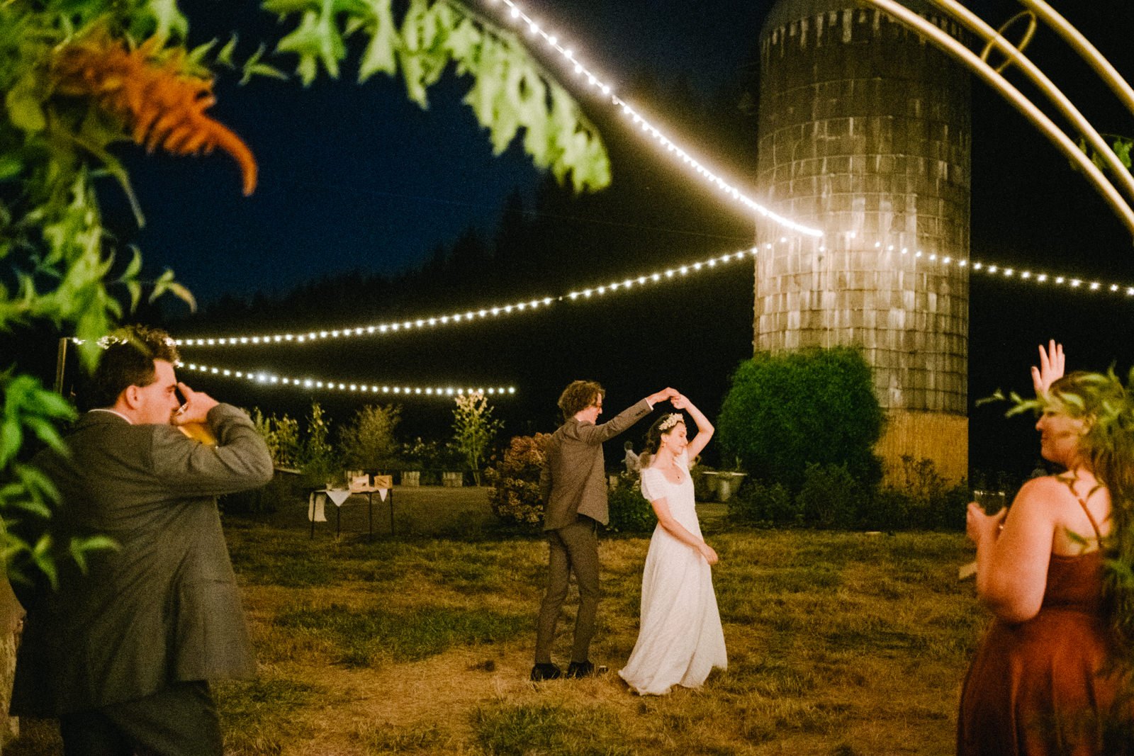  Couple dances under bulb lights by silo at Clackamas River Farm 