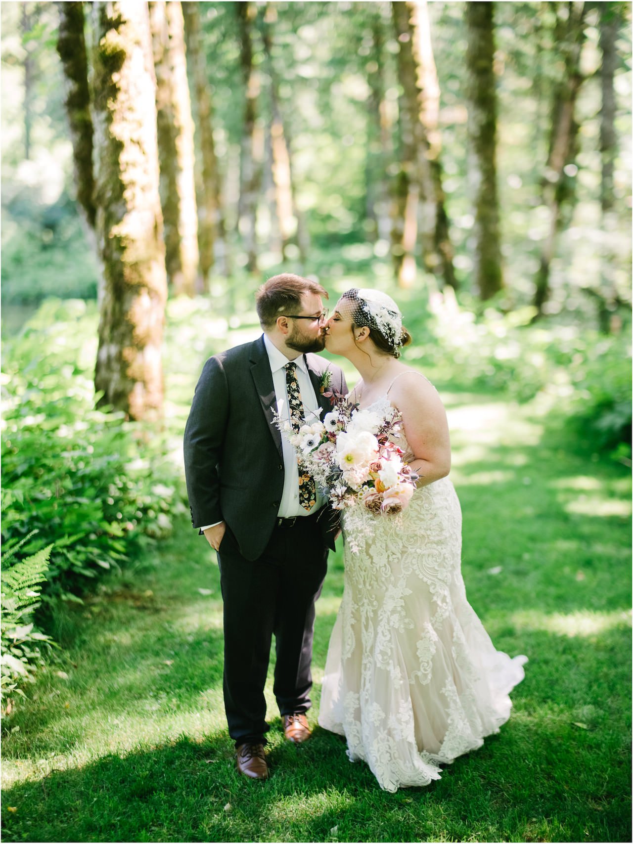  Bride and groom kiss while walking down path of tree groves at bridal veil 
