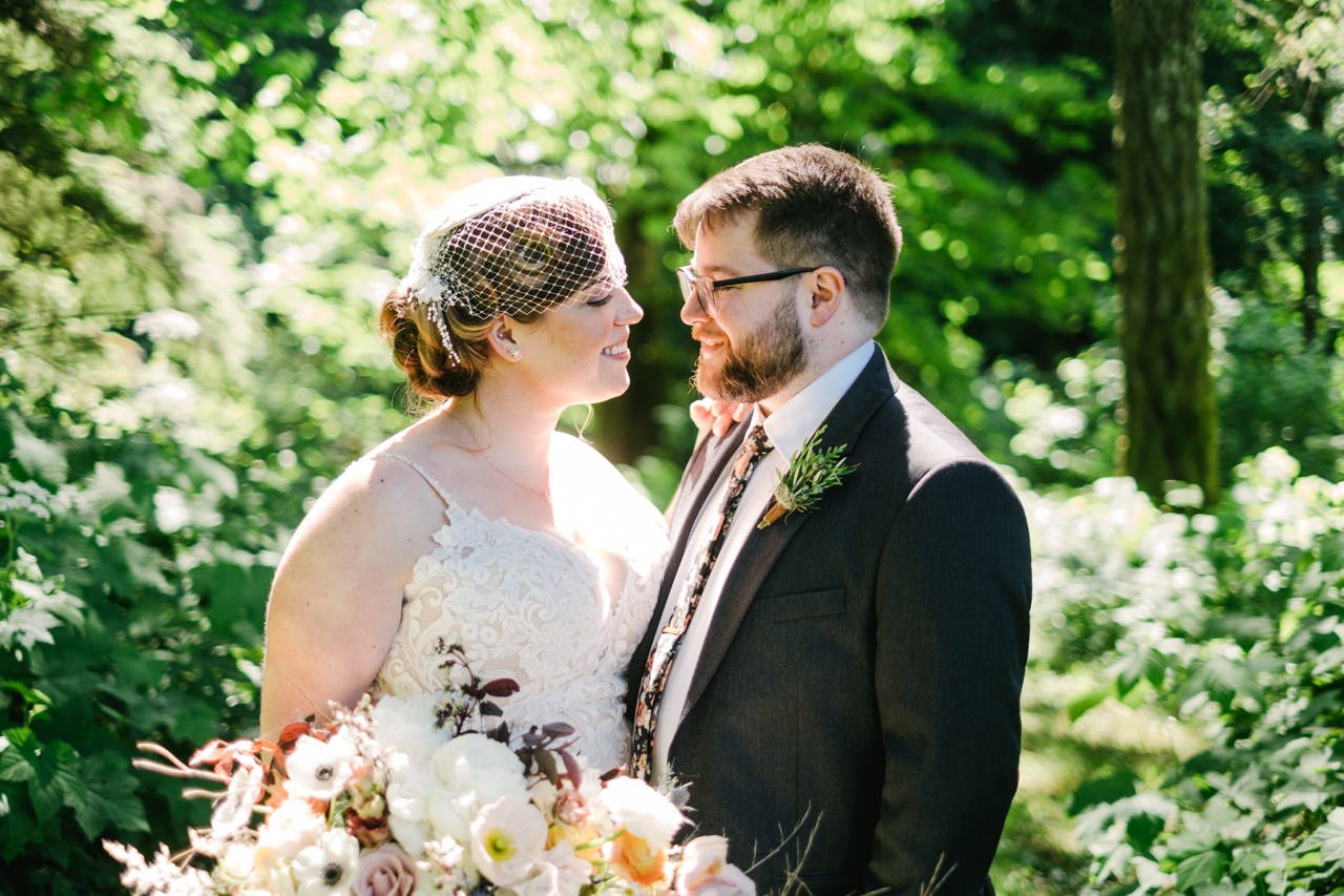 Bride and groom with rosemary boutonniere smile in sunlight 