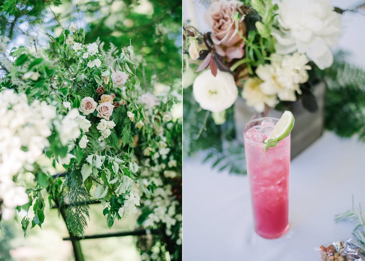  Specialty pink alcohol drink in front of burn rose florals and ferns 