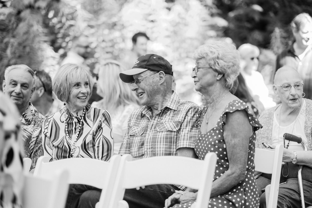  Black and white photo of elderly wedding guests smiling together 