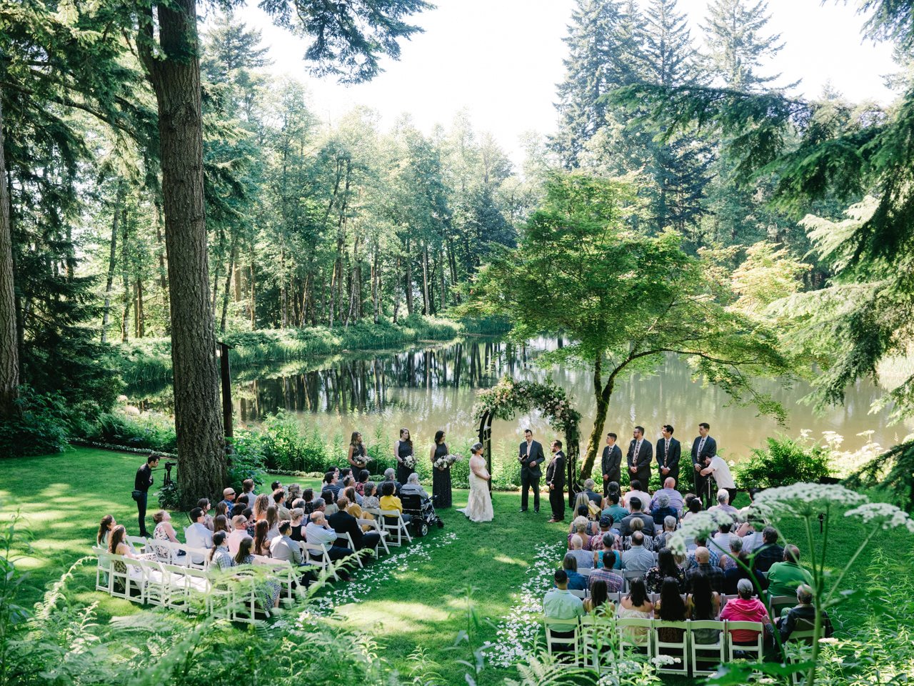  Wide angle photo of wedding ceremony in front of bridal veil lake in sunlight 