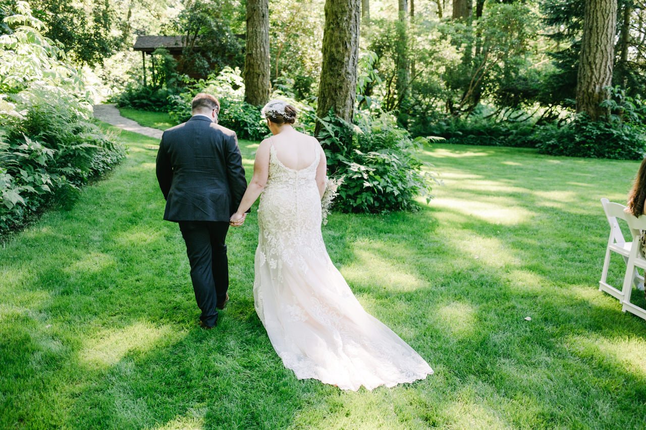  Bride and groom walk away in dappled sunlight 