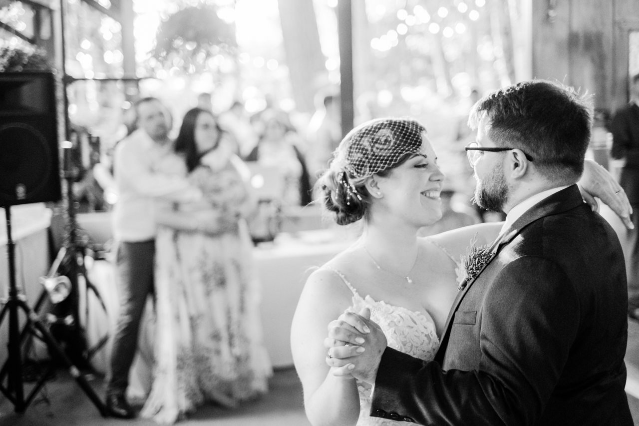  Bride smiles at groom in black and white first dance photo 