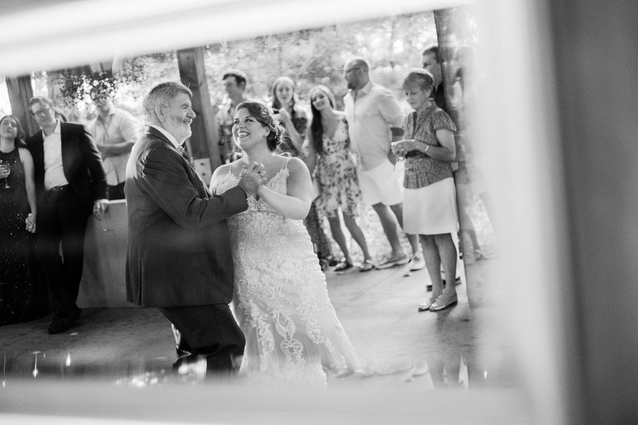  Reflection in mirror of father daughter dance smiling in emotional moment 