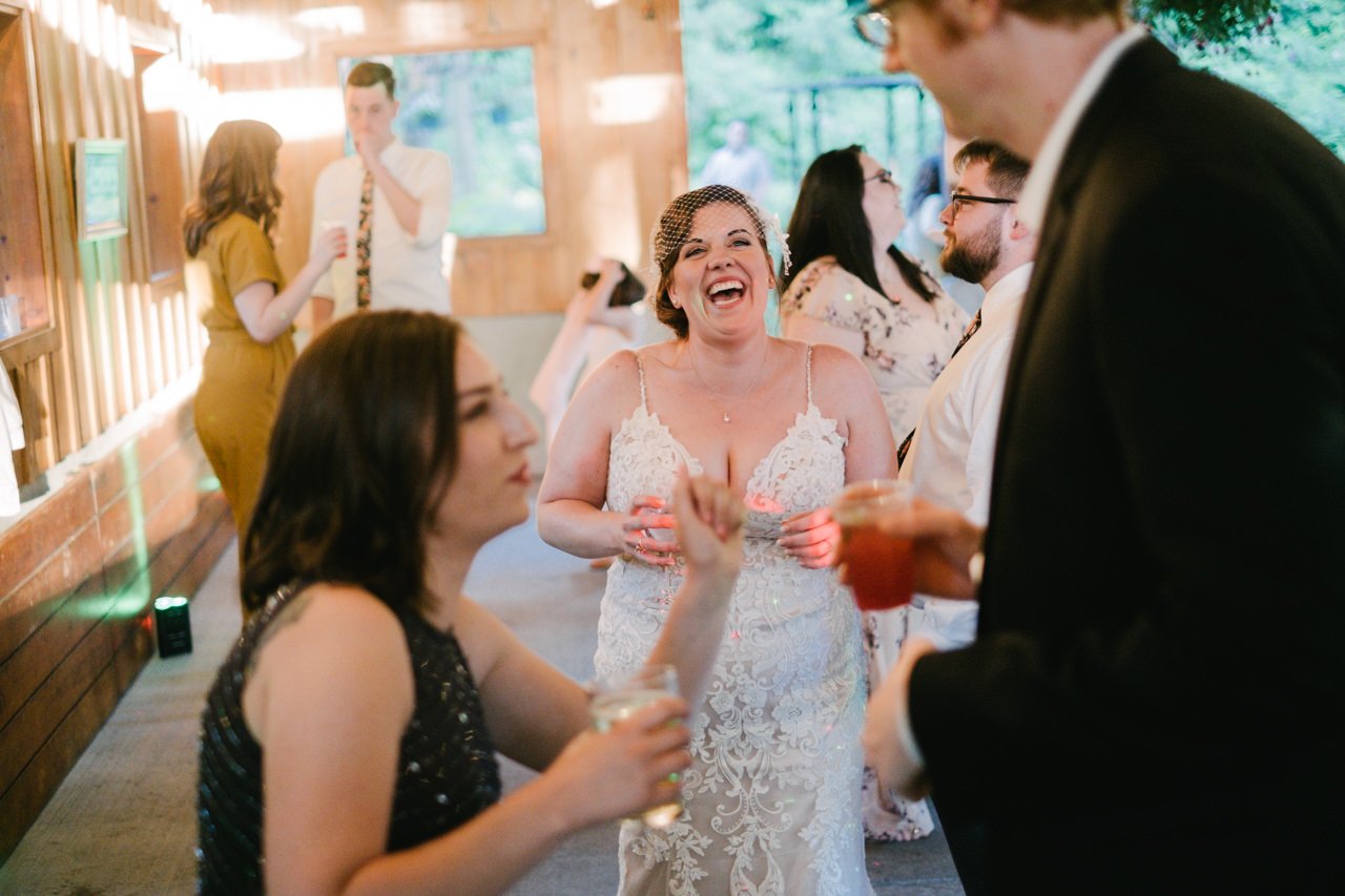  Bride giggles in laser lights and sunlight 