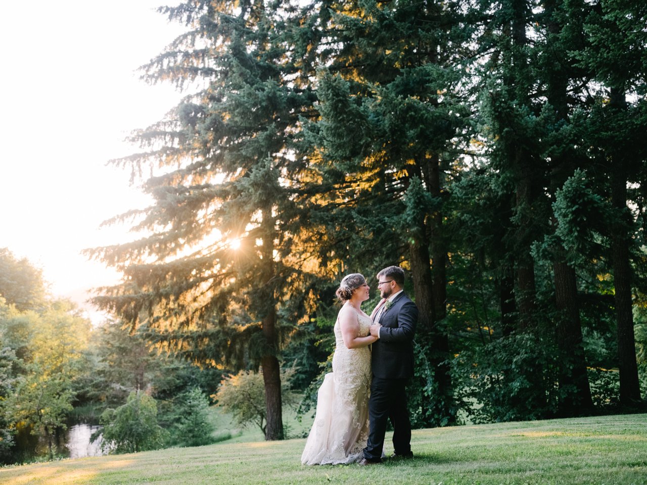  Sunset shines through tall fir trees at bridal veil lakes in evening wedding portraits 