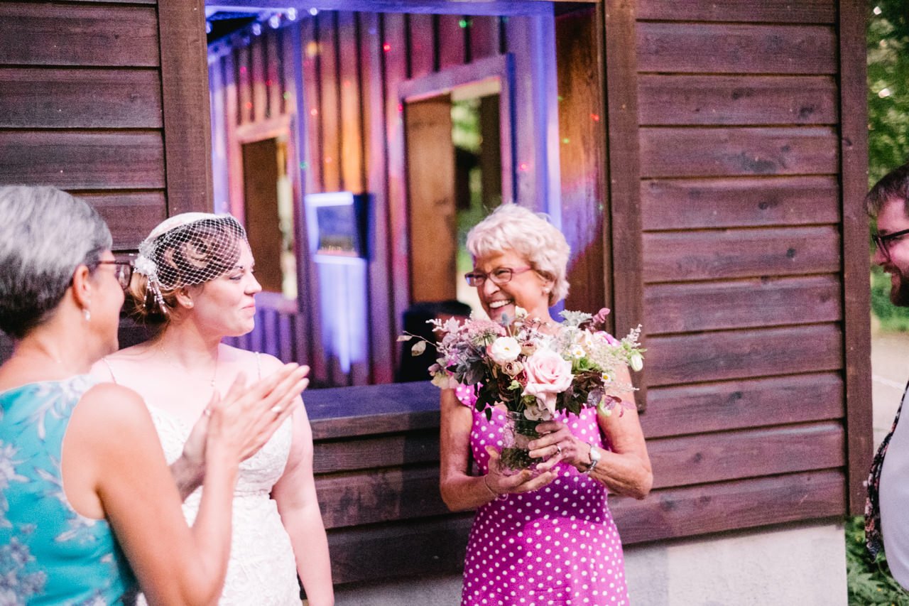  Aunt in purple polka dot dress holds bouquet 