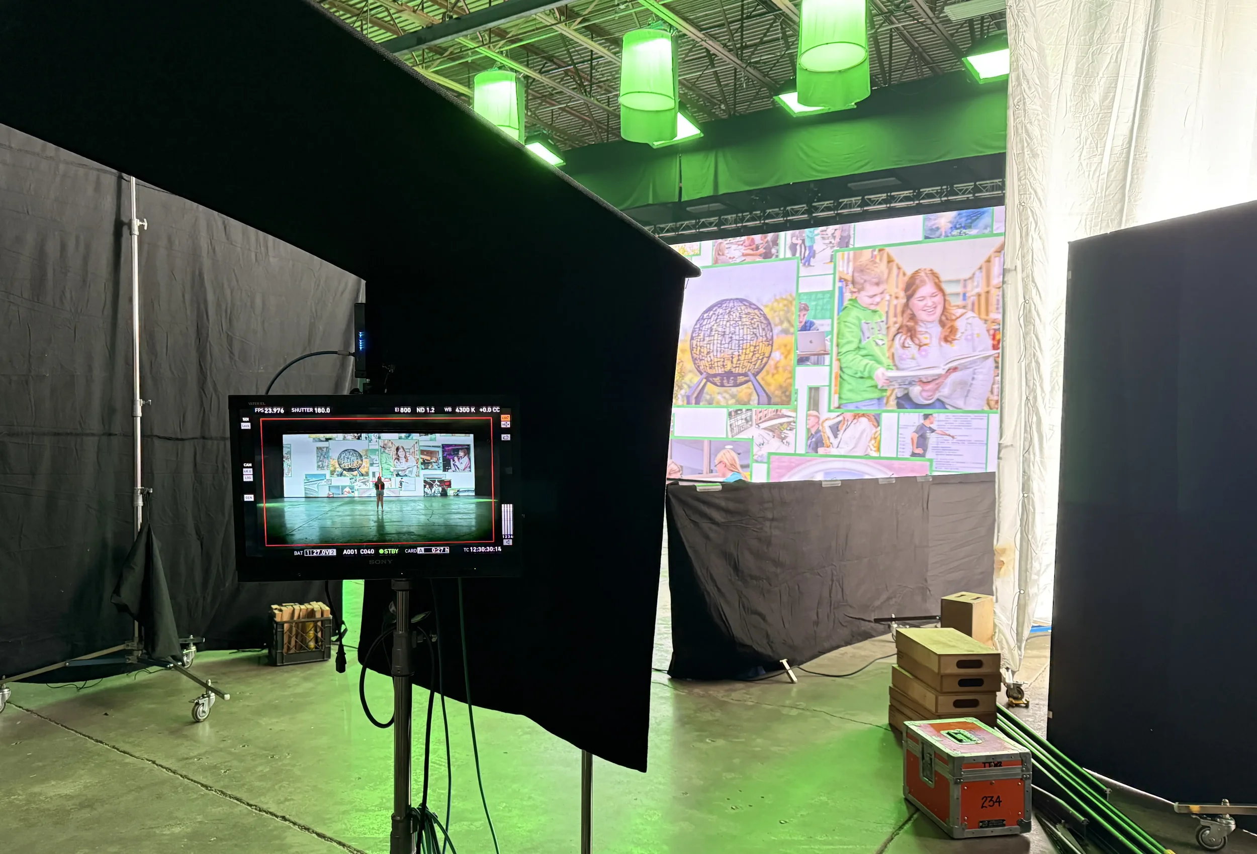 Behind the scenes of a video shoot looking at a playback screen.