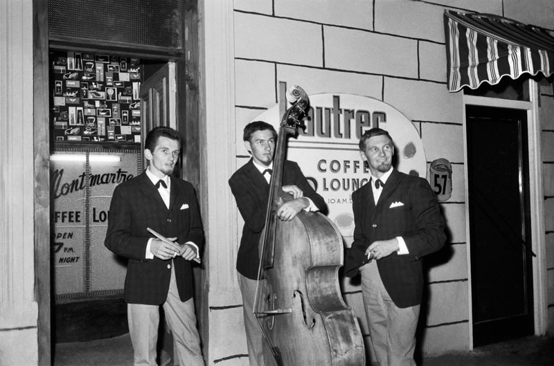 Rykenberg Photography, Seventeen days of Rykenberg, Central City Library Mike Walker trio outside the Montmartre and Lautrec Coffee Lounge in Lorne Street, 1960s, Sir George Grey Special Collections, Auckland Libraries