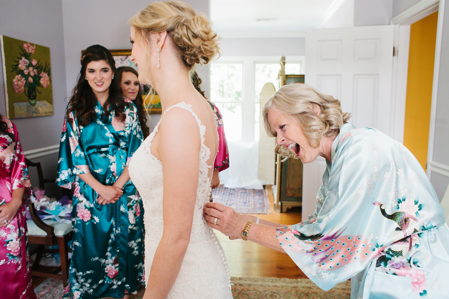 Bride Putting on Dress with Mom