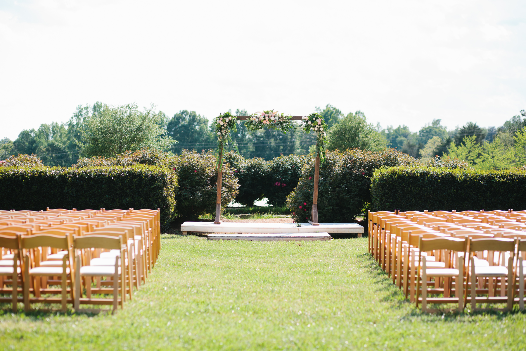 Outdoor Ceremony Decor with Floral Arch and Chairs