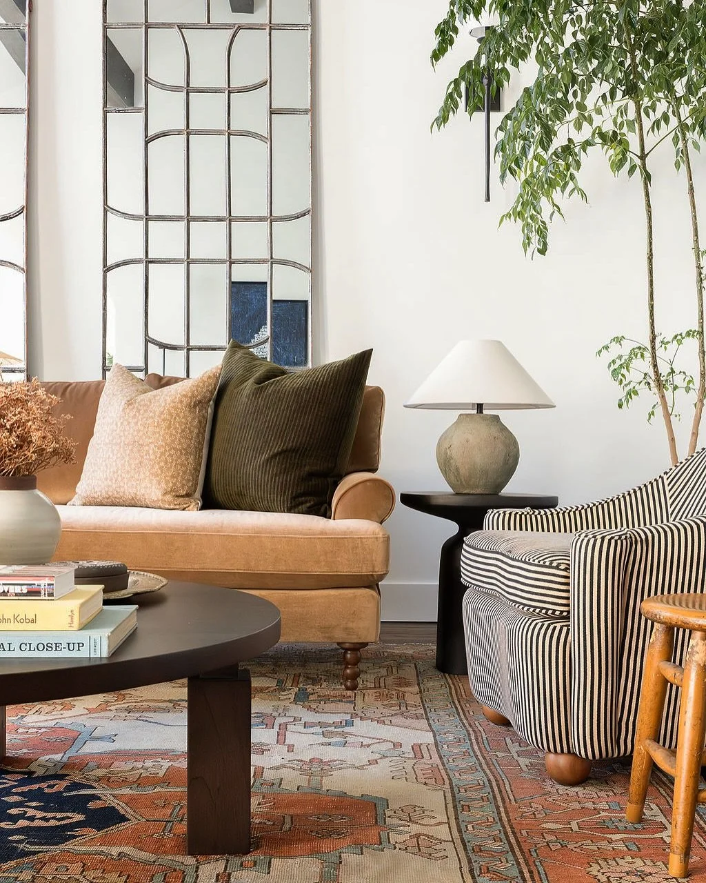 The two-story living room puzzle: show off the height but make it cozy. For this space we decided to smooth and plaster the walls, reface the fireplace, add beams, stain the floor darker and give the staircase a Spanish-inspired lift. The antique cat