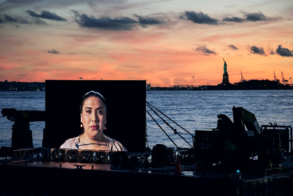 © Shimon Attie Night Watch (Mikaela with Liberty), Hudson River , Barge, Tugboat, 20’ wide hi-res LED screen, 30”X45”/48"X72" Lambda Photograph, Shimon Attie, 2018, courtesy of Jack Shainman Gallery, NY