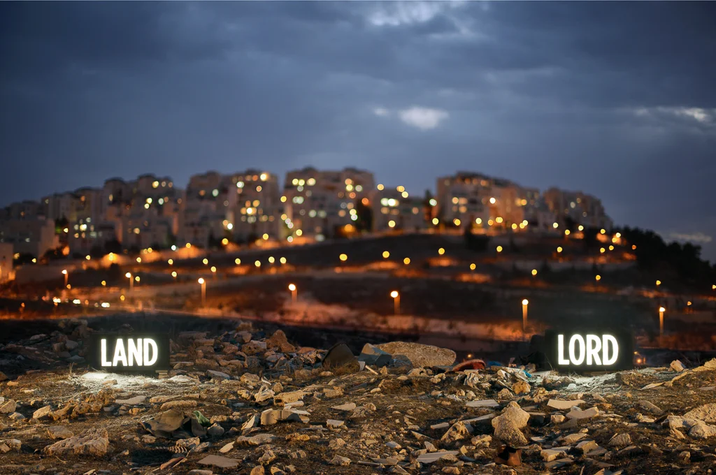 © Shimon Attie LAND LORD, Two on-location custom made light boxes, Looking onto Israeli settlement Har Homa from Palestinian Village Umm Tuba, annexed by Israel in 1967 , 27”X40”/48”X72” Lambda Photograph, Shimon Attie, from the project Facts on the Ground, 2014, courtesy of Jack Shainman Gallery, NY