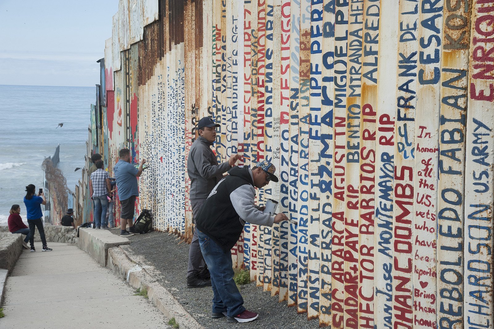 Painting names of deported US Veterans on the Wall.