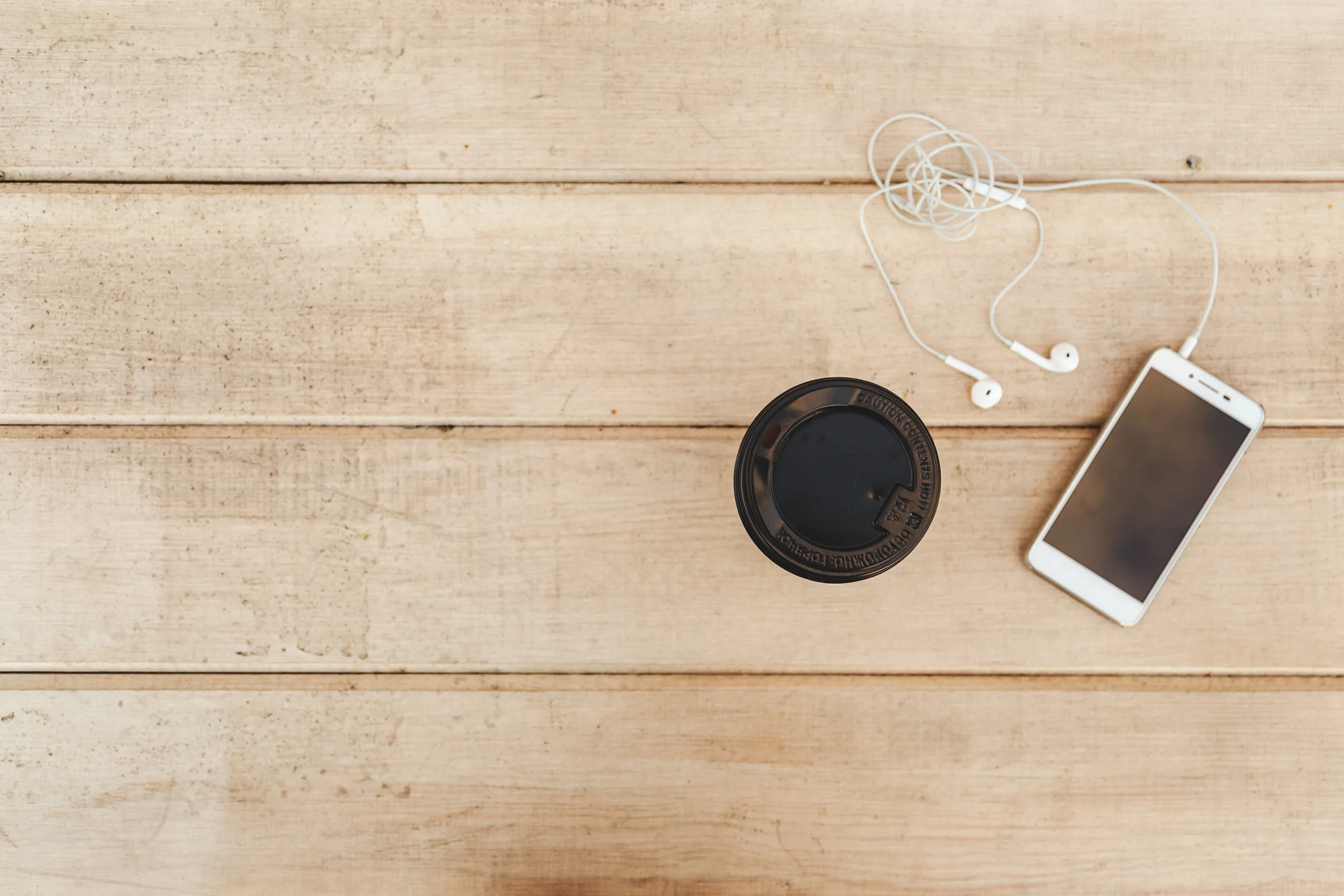 phone-with-headphones-and-coffee-on-wood-blank-P4SGPSH.jpg