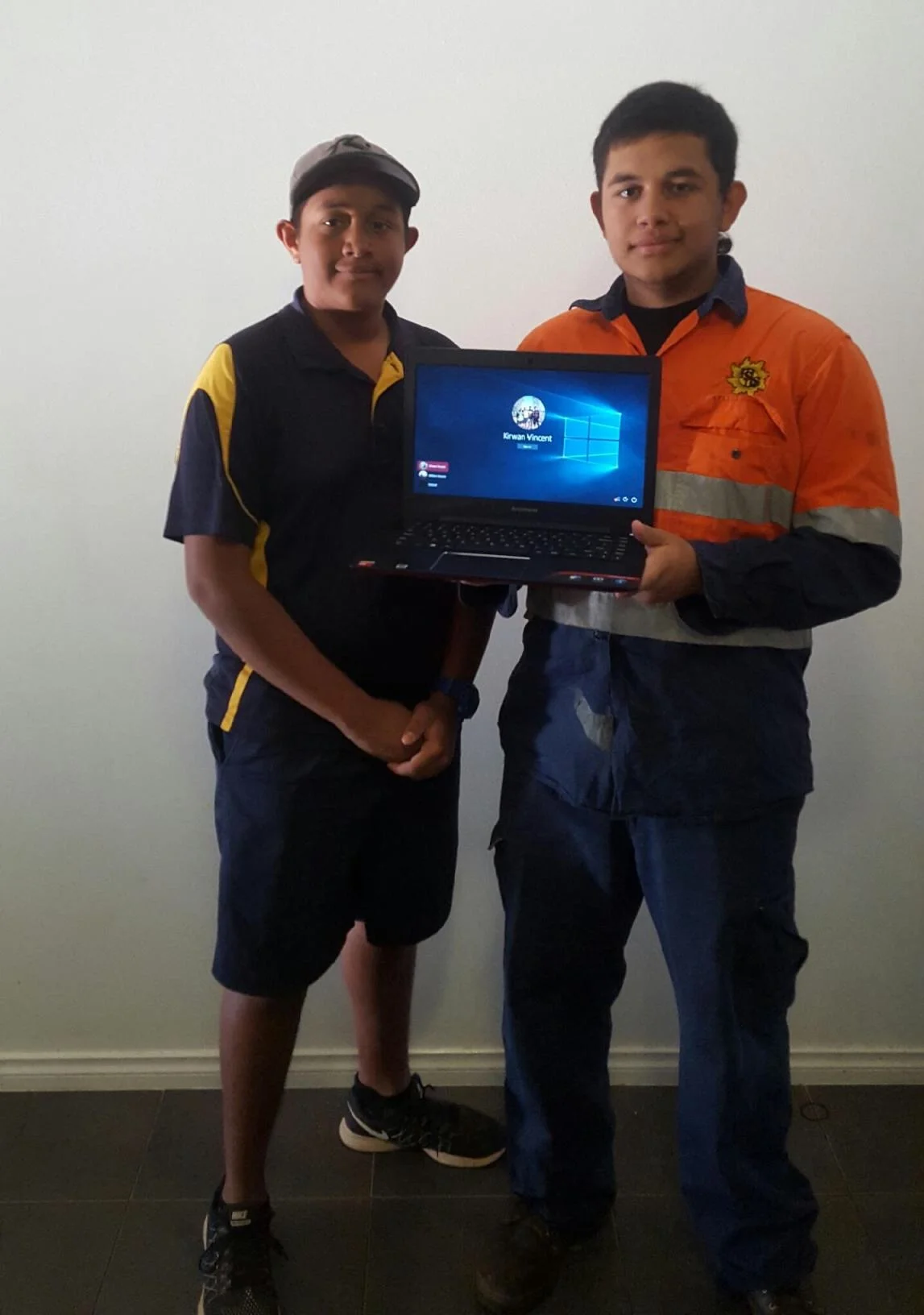 William and Kirwan Vincent with the laptop from the scholarship received from KRED Enterprises.