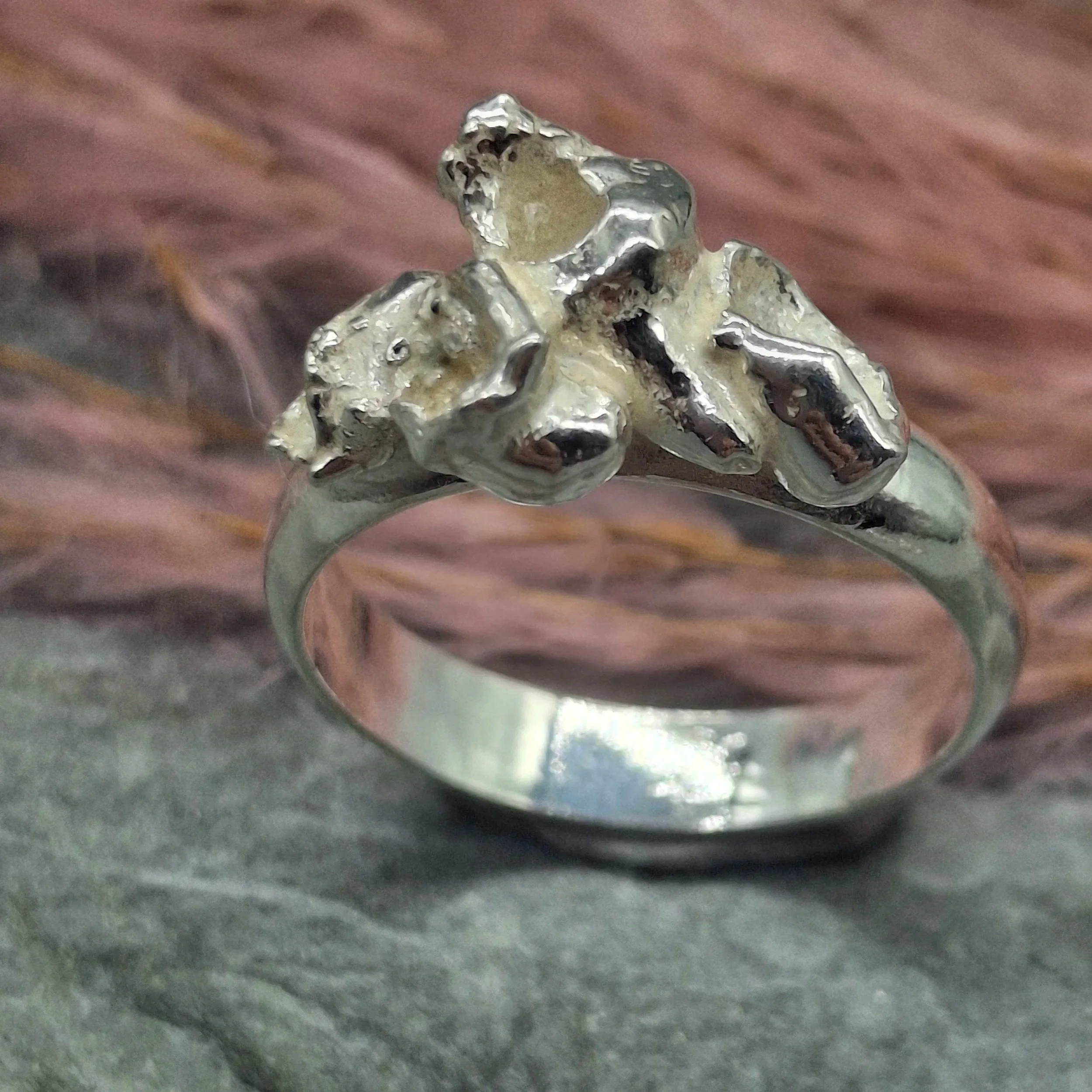 Handmade sterling silver Fallen Blossom ring with organic water-cast petal textures, inspired by fallen cherry blossom, with no gemstone.